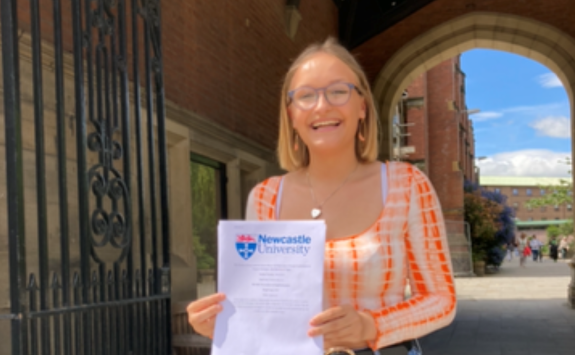 Olivia stood under the Arches proudly holding her dissertation